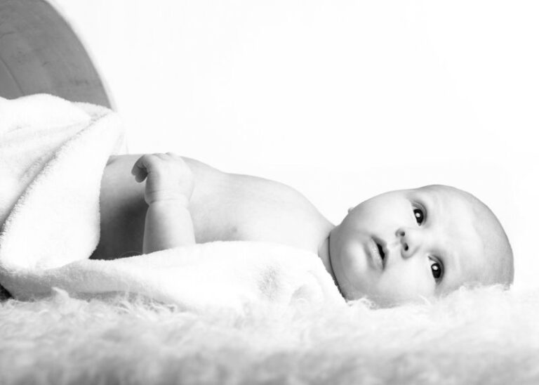 Das Foto zeig ein Baby liegt auf dem Boden