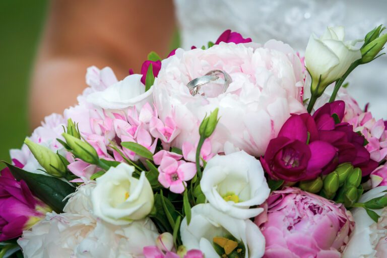 Foto zeigt einen Blumenstrauß mit Eheringen in einer Blüte.